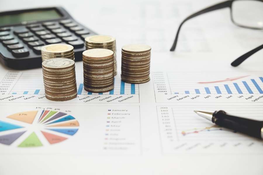 Des piles de pièces et des graphiques financiers pour l'ouverture d'un compte professionnel.
